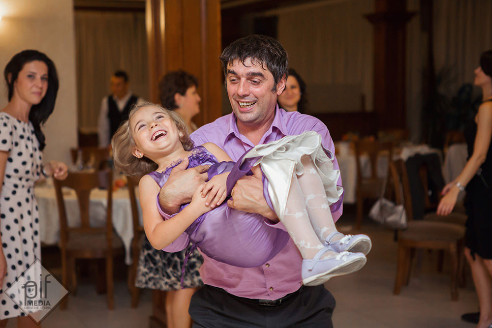 barbat in camasa mov cu fetita in brate la petrecere botez