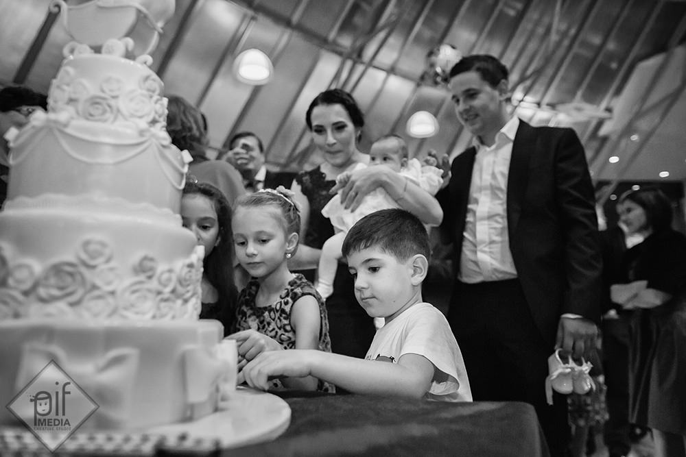 copii invitati la botez umbla la decoratiunile de pe tort