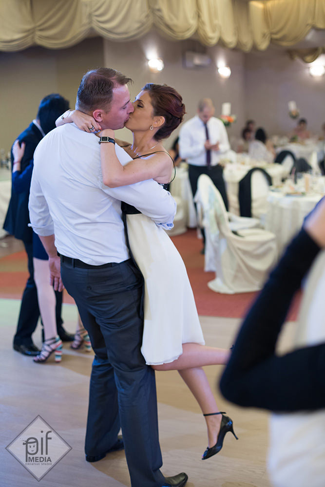doi invitati se saruta in timp ce barbatul o ridica pe femeie in timpul dansului