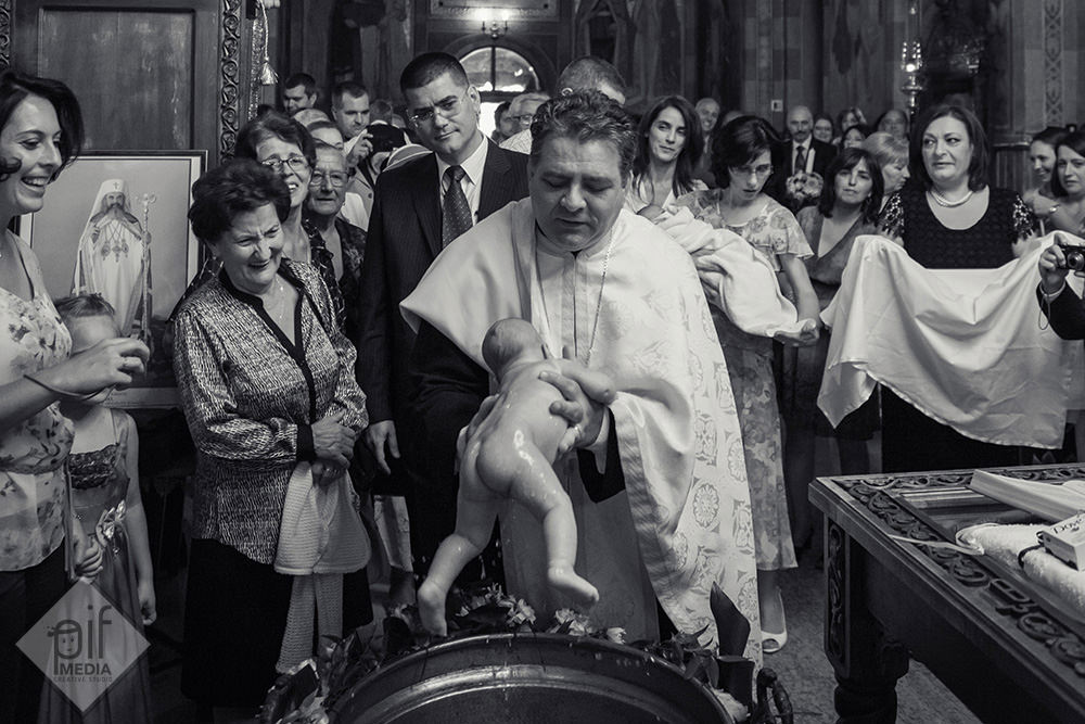 preotul scoate copilul din cristelnita
